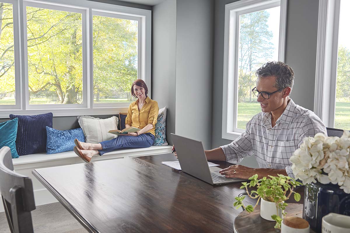 Couple sitting in dining room with man on laptop at table