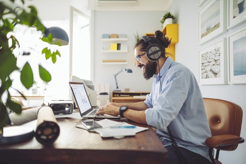 man at desk on computer working from home